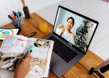 Online teaching session with digital tools, featuring a woman on a laptop screen and educational materials.